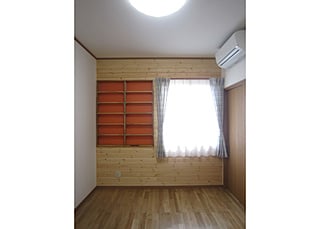 バックがオレンジ色の本棚は、壁の厚みを利用しています。